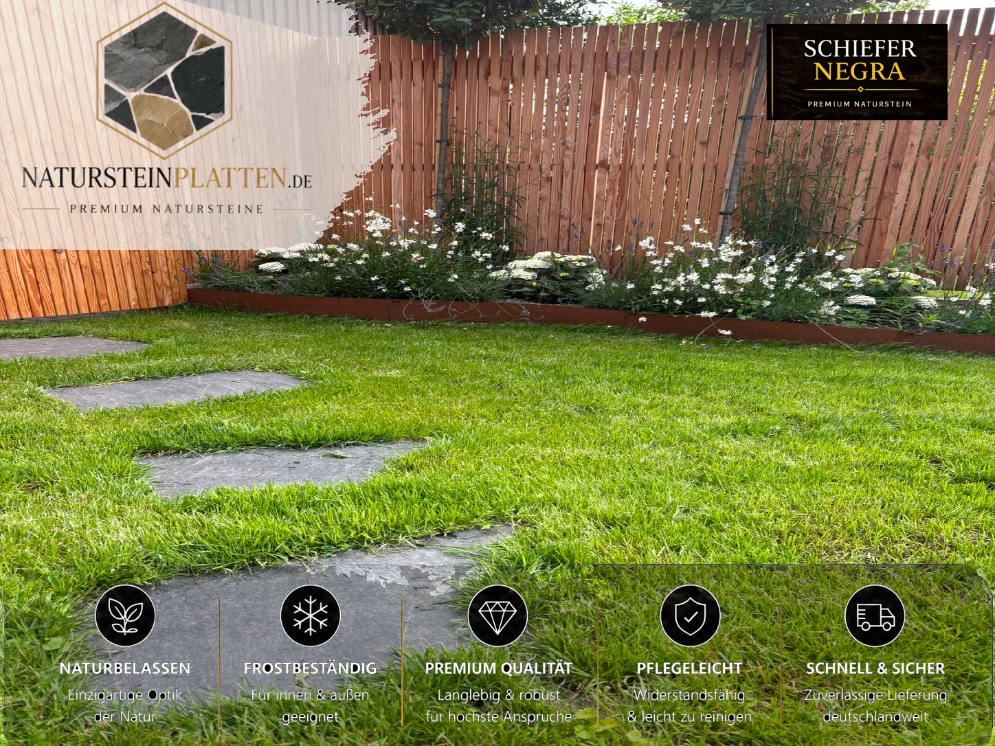 Polygonale Schiefer Trittplatten Negra als Gartenweg im Rasen entlang eines Blumenbeets mit modernem Holzzaun.